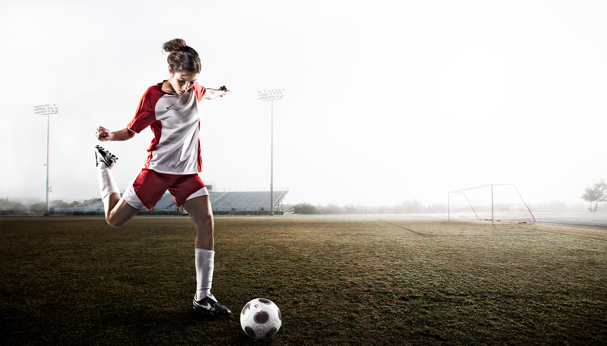 Female soccer player kicking ball | Dovis Bird Agency Photography